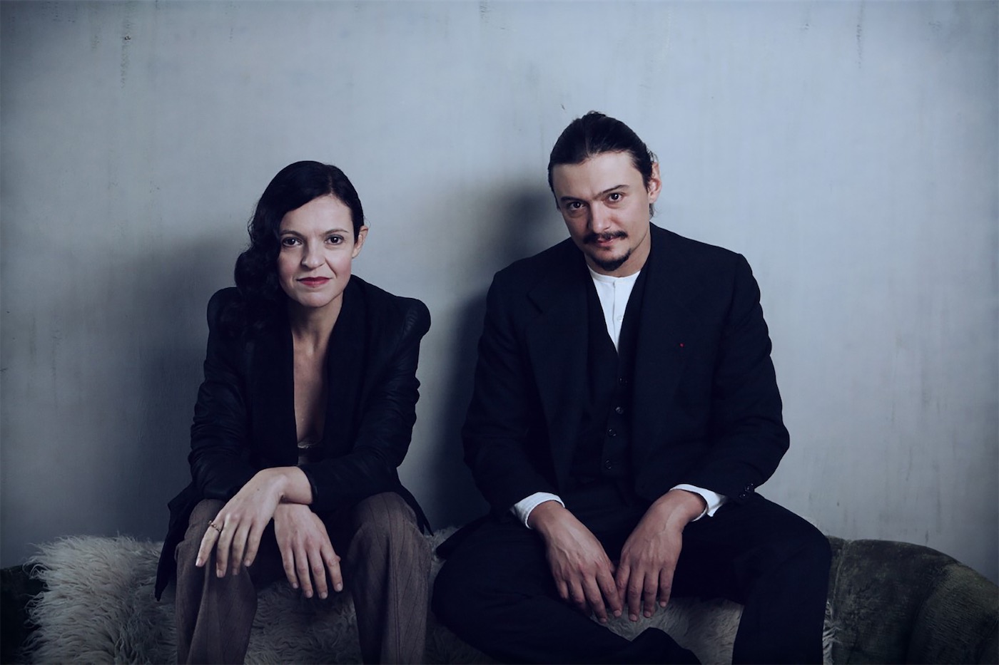 un ritratto di Monica Demuru e Cristiano Calcagnile, vestiti di scuro, che guardano in camera